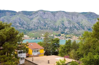 a yellow house with a view of a mountain at Central Apartment in Kotor
