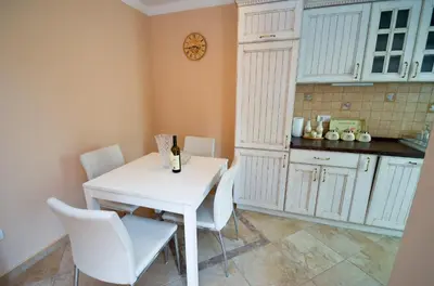a kitchen with a white table and white chairs at Central Apartment in Kotor