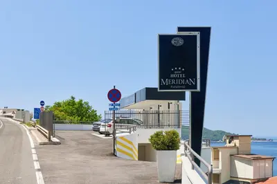 a sign on the side of a road near the water at Meridian Hotel in Budva