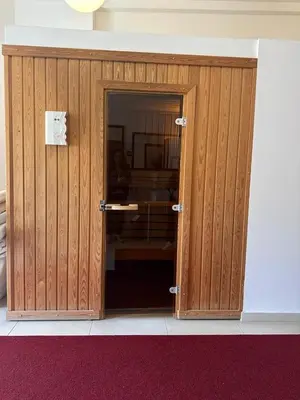 a wooden door in a room with a red carpet at Meridian Hotel in Budva