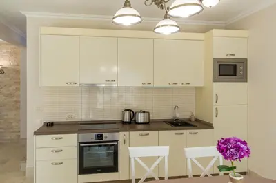 a kitchen with white cabinets and a stove top oven at Townhouse Virginia in Petrovac na Moru
