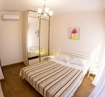 a bedroom with a bed and a large mirror at Townhouse Virginia in Petrovac na Moru