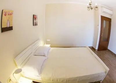 a bedroom with a large white bed in a room at Townhouse Virginia in Petrovac na Moru