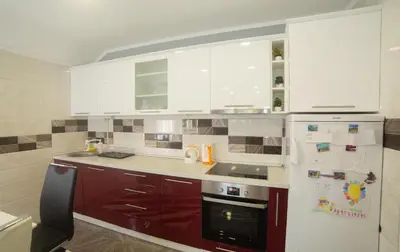 a kitchen with red cabinets and a white refrigerator at Apartment Milena in Virpazar