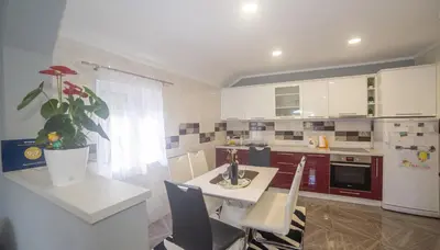 a kitchen with a table and a white refrigerator at Apartment Milena in Virpazar