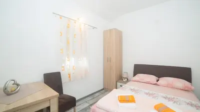 a bedroom with a bed and a desk and a table at Apartment Milena in Virpazar