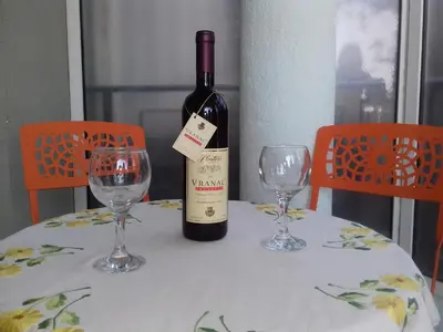 a bottle of wine sitting on a table with two glasses at Aleksandra in Becici