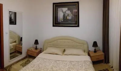 a bedroom with a bed and two night stands with lamps at Aleksandra in Becici