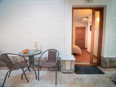 a patio with a table and chairs and a bedroom at Apartments and Rooms Levantin Inn in Sveti Stefan