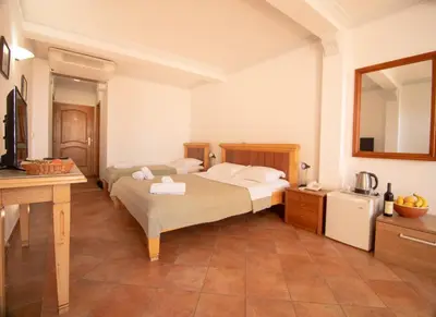 a hotel room with two beds and a sink at Apartments and Rooms Levantin Inn in Sveti Stefan