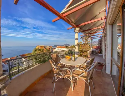 a patio with a table and chairs on a balcony at Apartments and Rooms Levantin Inn in Sveti Stefan