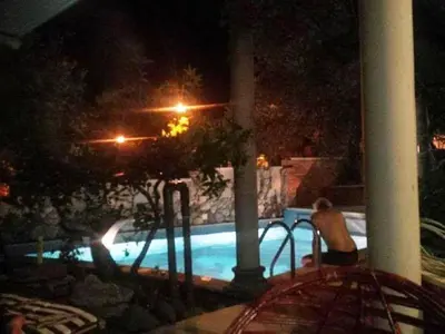 a swimming pool at night with a pool at Apartments and Rooms Levantin Inn in Sveti Stefan