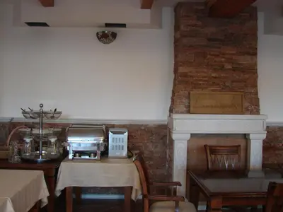 a dining room with a table and a fireplace at Apartments and Rooms Levantin Inn in Sveti Stefan
