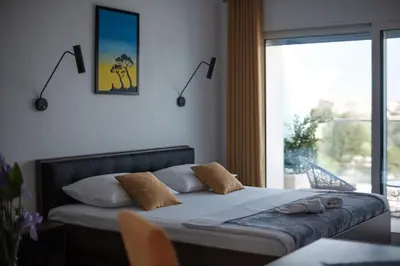 a bedroom with a bed and a large window at Sunset Apartments in Ulcinj