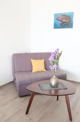 a living room with a purple couch and a table at Sunset Apartments in Ulcinj