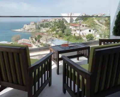 a balcony with a table and chairs and a view of the ocean at Sunset Apartments in Ulcinj