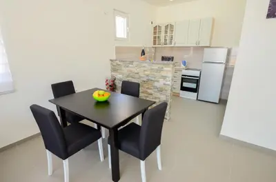 a kitchen with a black table and chairs in a room at Four Seasons Apartments in Kotor