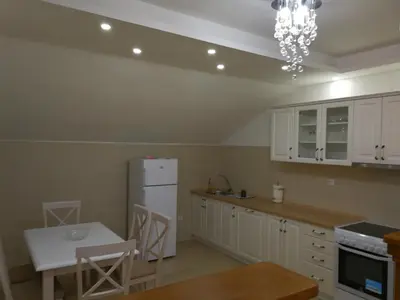 a kitchen with white cabinets and a white refrigerator at Apartment Misulino in Kotor