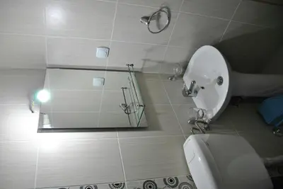 a bathroom with a white toilet and a mirror at Haamel Apartment in Ulcinj