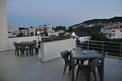 a group of tables and chairs on a balcony at Haamel Apartment in Ulcinj