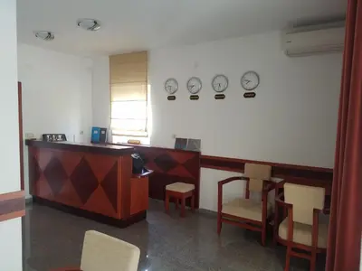 a waiting room with a desk and chairs and clocks on the wall at Villa Swan in Bar