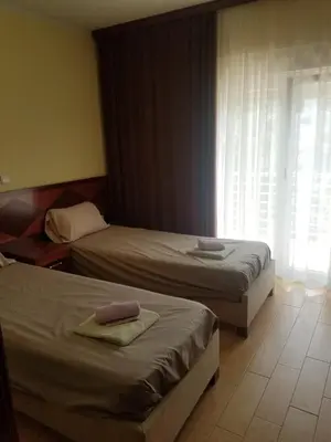 a hotel room with two beds and a window at Villa Swan in Bar