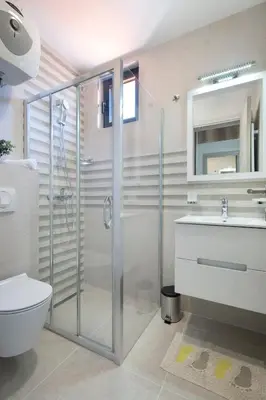 a bathroom with a shower and a toilet and a sink at Apartments Djuro Rafailovic in Budva