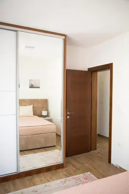 a bedroom with a bed and a mirror at Apartments Sunny Hill in Tivat
