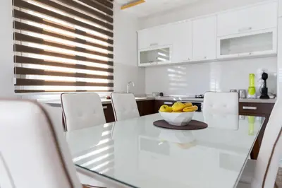 a kitchen with a table with a bowl of fruit on it at Apartments Sunny Hill in Tivat