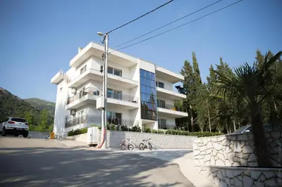 a white apartment building with a bike parked in front of it at Apartments Sunny Hill in Tivat