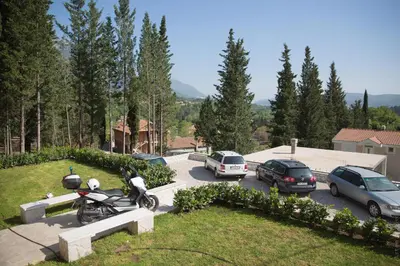 a motorcycle parked in a parking lot with parked cars at Apartments Sunny Hill in Tivat