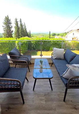 a patio with two couches and a table on a porch at Apartments Sunny Hill in Tivat