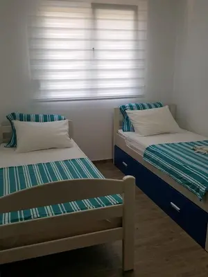 two twin beds in a room with a window at Apartments Sunny Hill in Tivat