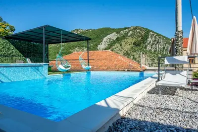 a swimming pool with a view of a mountain at Apartments Golden View in Kotor