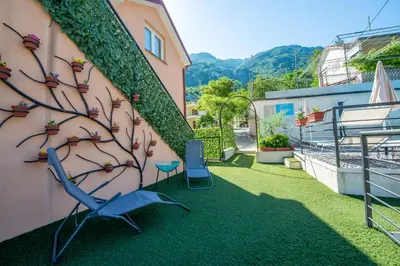a wall with a sculpture of a tree on the side of a building at Apartments Golden View in Kotor