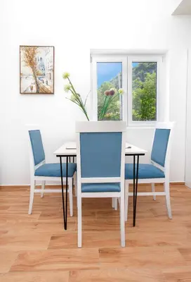 a dining room with two chairs and a table with a vase at Apartments Golden View in Kotor