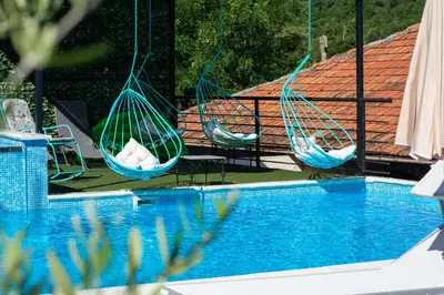 two hammocks are hanging over a swimming pool at Apartments Golden View in Kotor