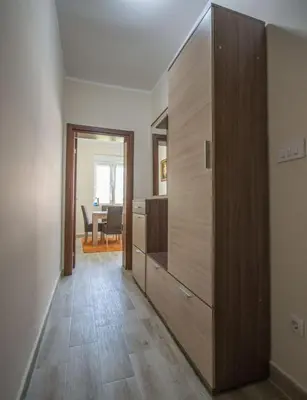 a hallway with a large wooden cabinet and a dining room at Magnolia Old Town in Kotor