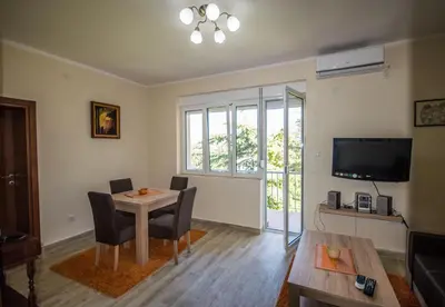 a living room with a table and chairs and a television at Magnolia Old Town in Kotor
