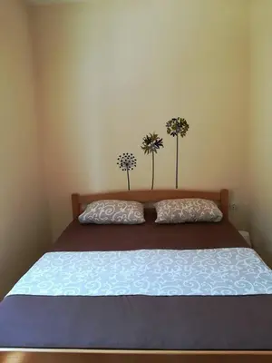 a bed with two flowers on top of it at Luxury Apartment Maja in Tivat