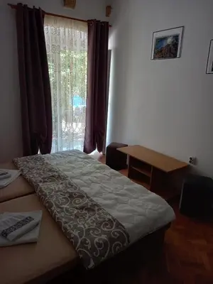 a bedroom with a bed and a window and a desk at Guesthouse Nikoleta in Kotor