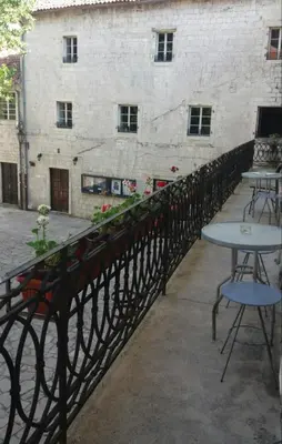 a balcony with tables and chairs and a building at Guesthouse Nikoleta in Kotor