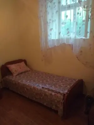 a small bed in a room with a window at Apartman 