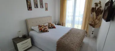a bedroom with a white bed with pillows and a window at Royal Apartment Bar in Bar