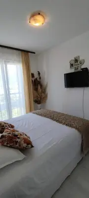 a bedroom with a bed with a television on the wall at Royal Apartment Bar in Bar