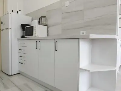 a kitchen with white cabinets and a white refrigerator at Royal Apartment Bar in Bar
