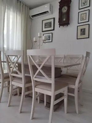 a dining room table and chairs with a clock on the wall at Royal Apartment Bar in Bar