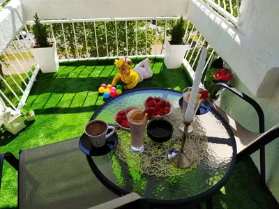 a balcony with a table and a toy on the grass at Royal Apartment Bar in Bar