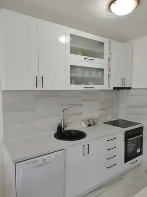 a white kitchen with white cabinets and a sink at Royal Apartment Bar in Bar