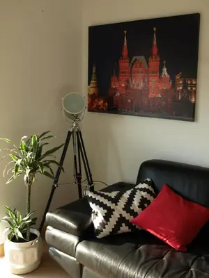 a black leather couch in a living room with a painting at Red Lux in Budva